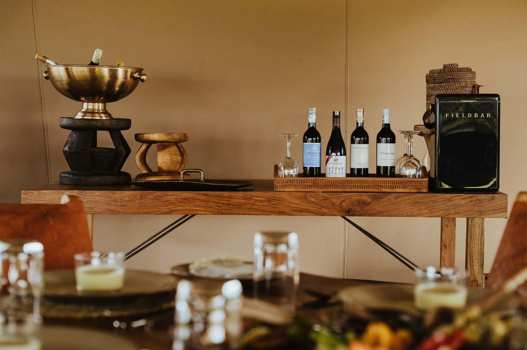 dining area with wine and food by Wilderness Usawa tented camp Serengeti
