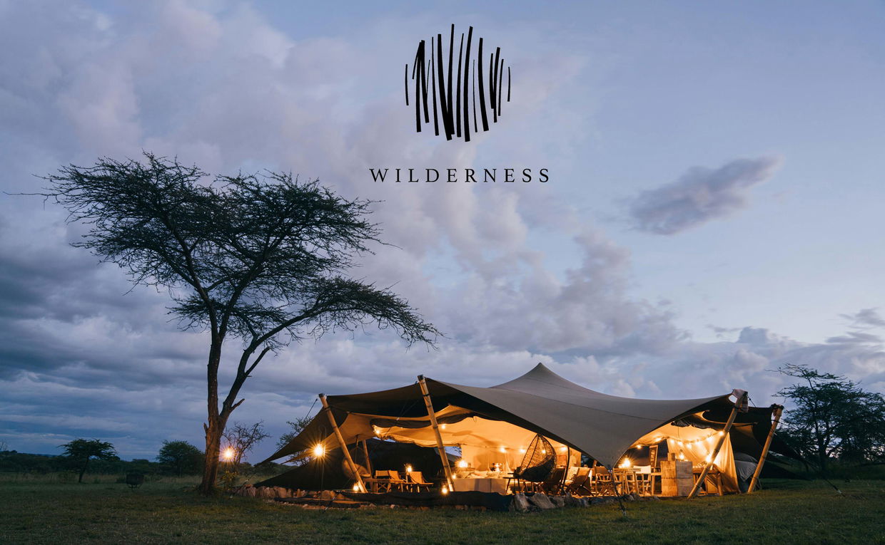 sunset exterior view of Wilderness Usawa tented camp Serengeti with logo overlay
