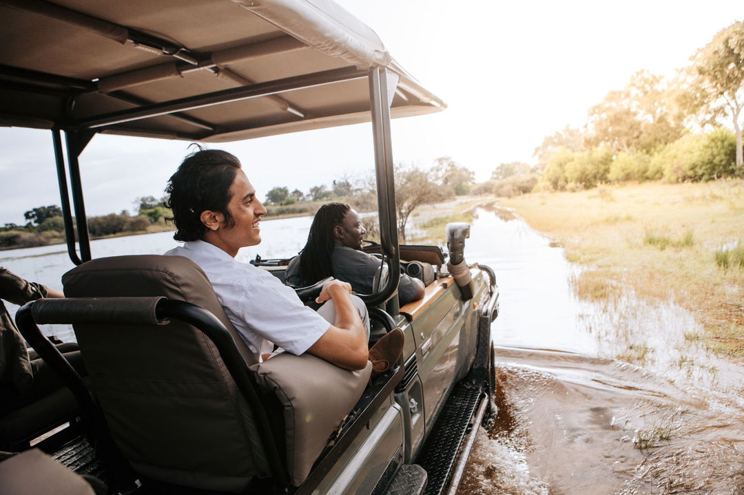 guest with safari guide in open vehicle looking to the side at Vumbura Plains Camp Wilderness Okavango Delta