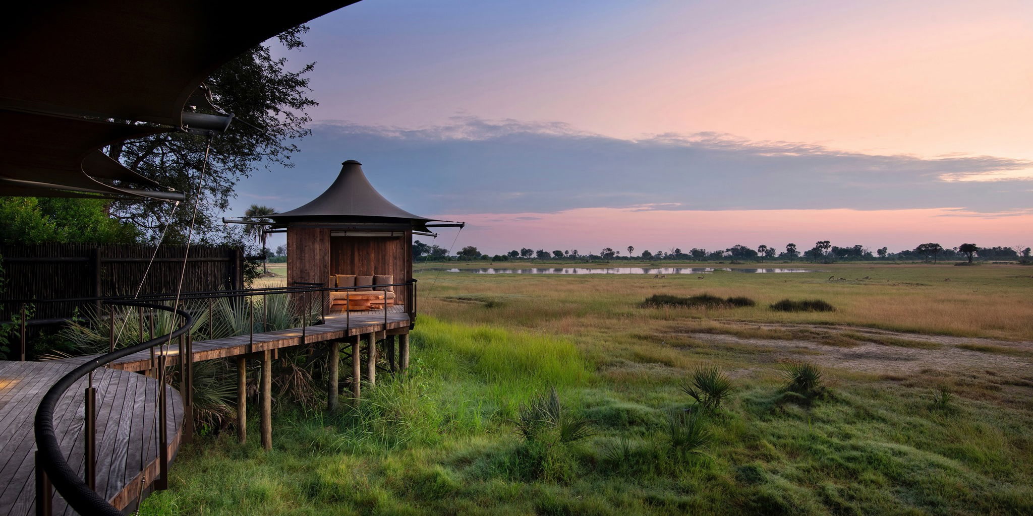 side view of Xigera Lodge Botswana with delta views beyond at sunset