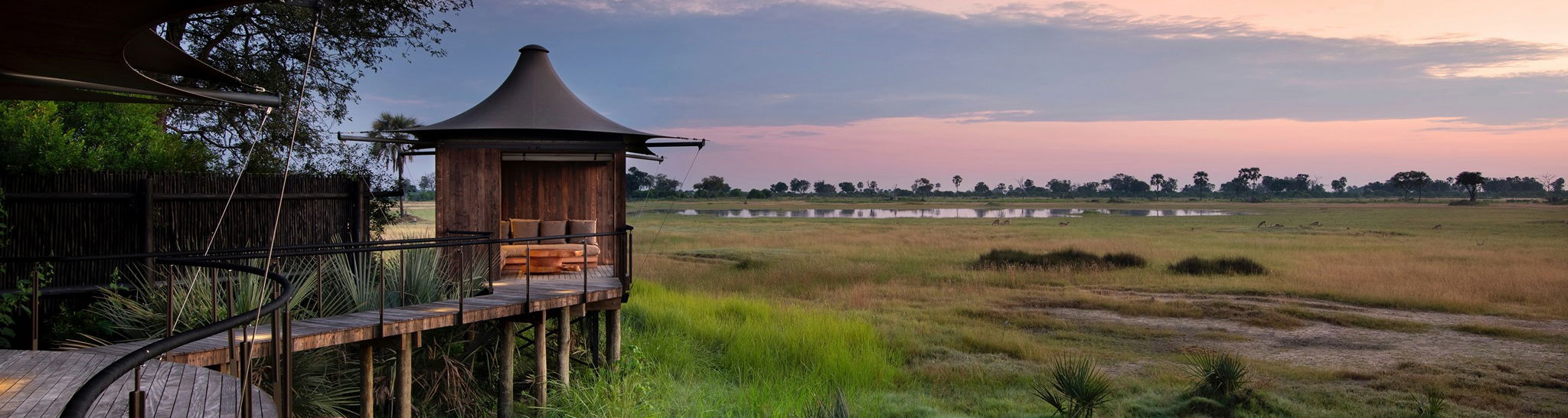 side view of Xigera Lodge Botswana with delta views beyond at sunset