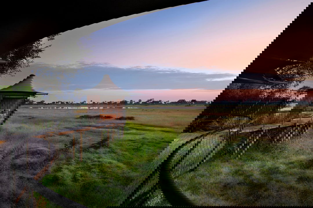 side view of Xigera Lodge Botswana with delta views beyond at sunset