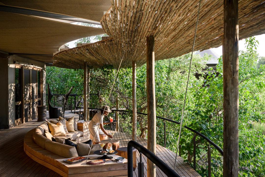 Staff serving drinks on viewing deck at Xigera lodge Botswana