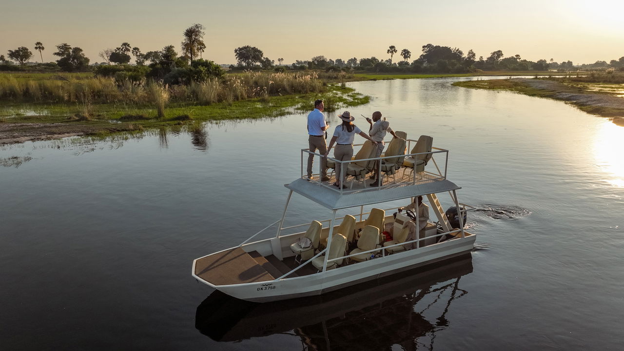guest on a sundowner boat cruise on the Okavango delta at Xigera Lodge Botswana