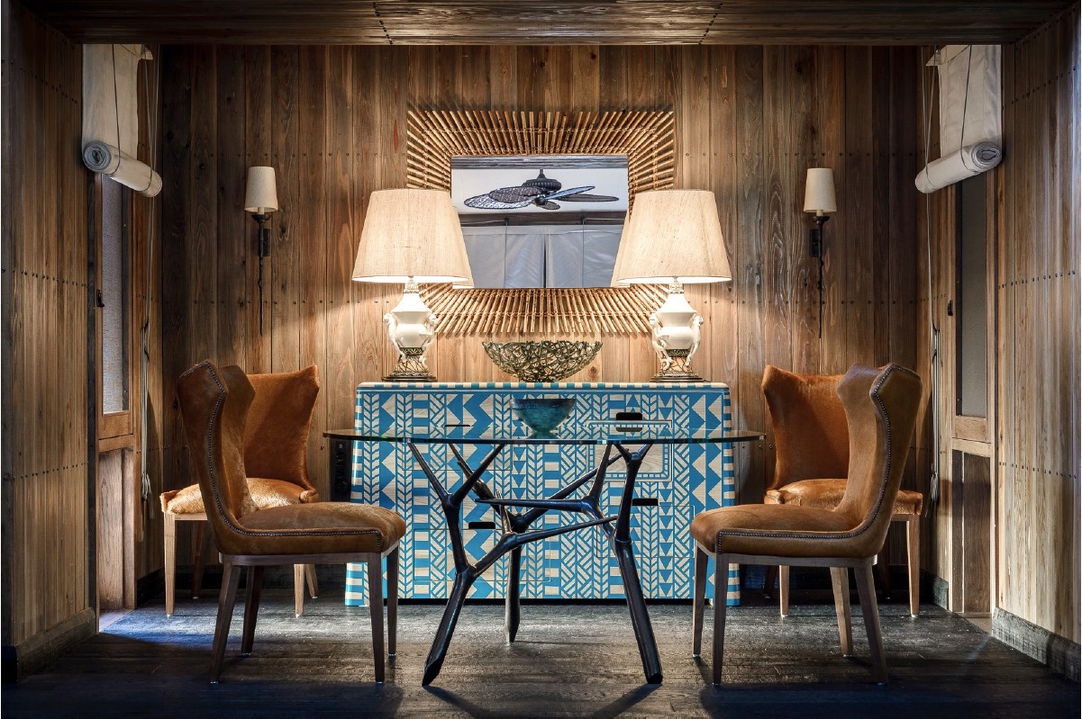 table with leather chairs in lounge area of suite at Xigera Lodge Botswana