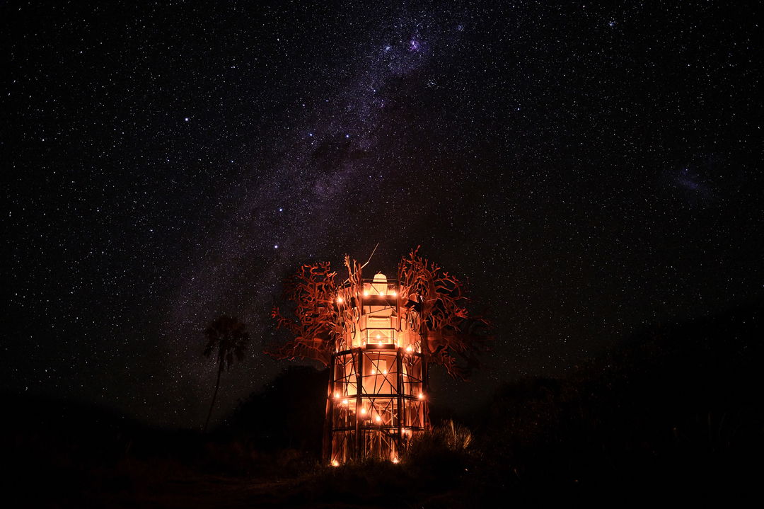 illuminated tree house with starry sky beyond at Xigera Lodge Botswana
