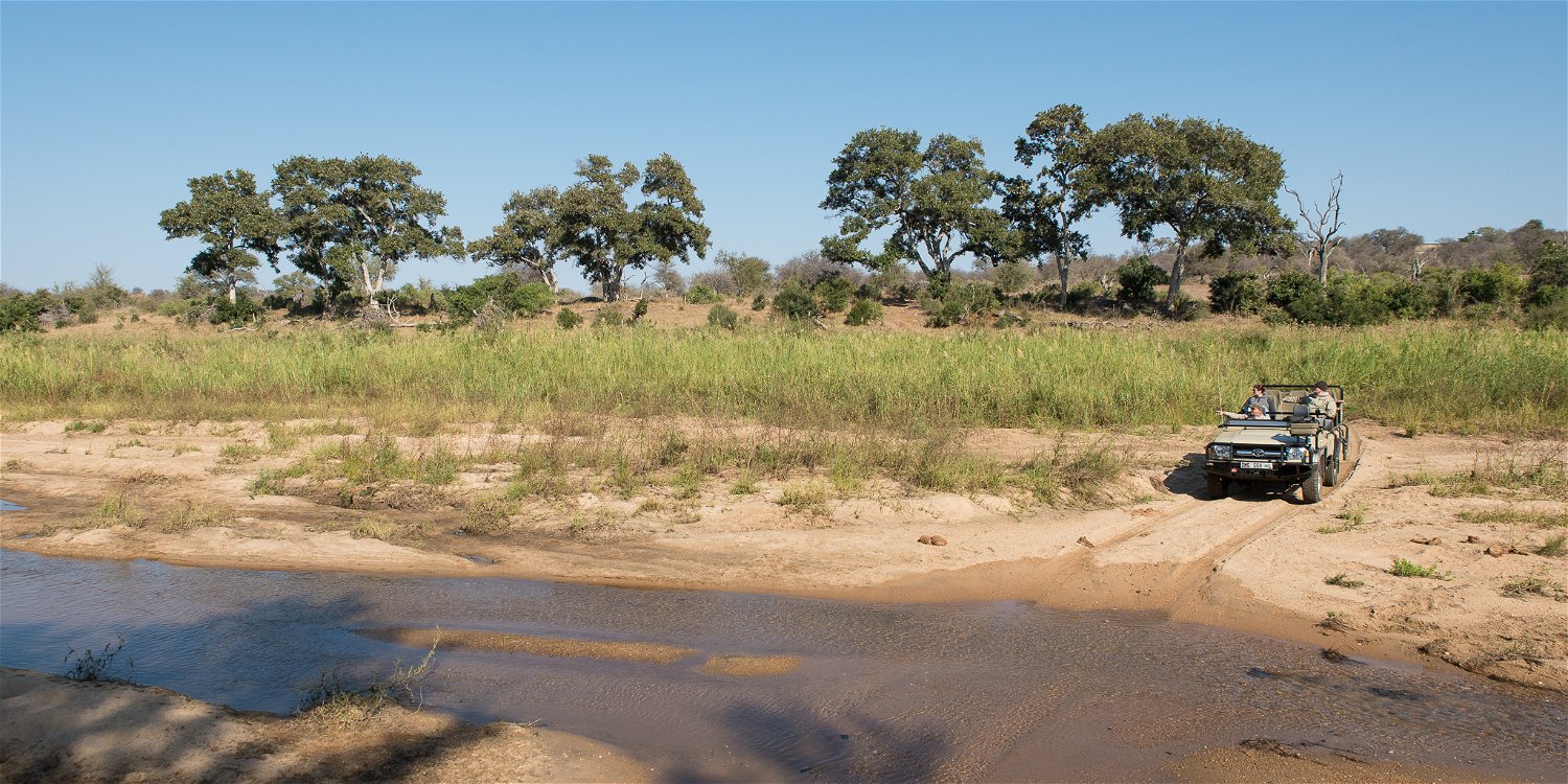 A safari game vehicle crossing the river in the Greater Kruger at Klaserie Drift