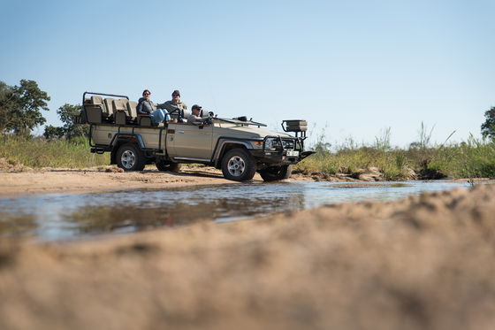 Safari game vehicle crossing Klaserie river with guests